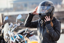 Motorcyclist Caucasian Woman Sets Her Full-face Helmet, Portrait Against Bikes Background, Copy Space