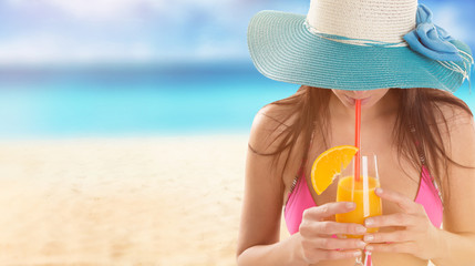 Wall Mural - Woman in bikini and sun hat relaxing at sunny beach.