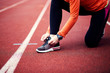 © Novak - Cropped shot view of female jogger tying laces on her running shoes