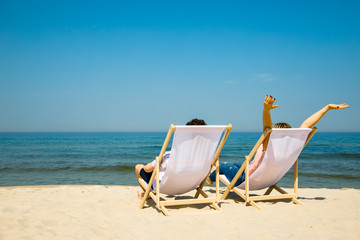 Wall Mural - Woman and man relaxing on beach