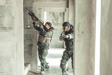 Special force soldiers in urban combat training.  Breach and entry building. Chinese soldiers in full combat gear, green digital cammo.