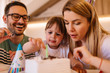 © Nebojsa - Happy family celebrating birthday with birthday cake. Father and daughter are taking pieces of chocolate from birthday cake.