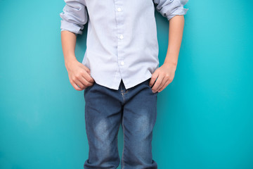 Young boy isolated in blue. Handsome early teenage boy portrait. Cool looking pose.