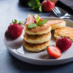 Wall Mural - Cottage cheese pancakes withstrawberry on blue concrete table background. Breakfast or Lunch Concept. Copy space