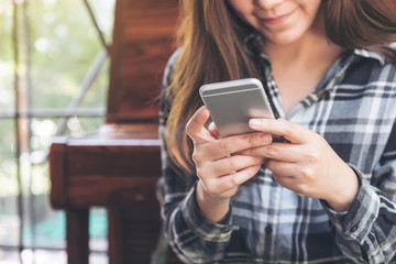 Canvas Print - Closeup image of a woman holding , using and looking at smart phone