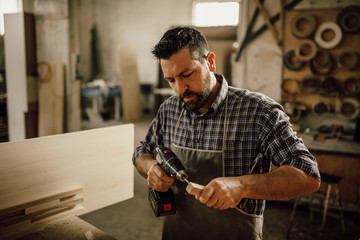 Wall Mural - handsome joiner work in carpentry. He is successful entrepreneur at his workplace.