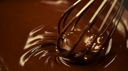 Wall Mural - Chocolate. Mixing melted dark chocolate with a whisk. Closeup of liquid hot chocolate swirl. Confectionery. Slow motion 4K UHD video 3840X2160