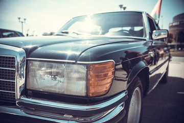 Wall Mural - close up front view of old classic car headlight is outdoor with bokeh background