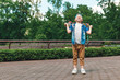 © Aliaksandr Marko - A small city boy and a skateboard. A young guy is standing in the park and holding a skateboard. City Style. City children. A child learns to ride a skateboard
