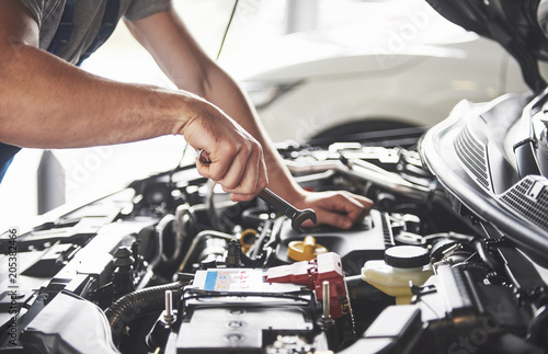 Fotomural Picture showing muscular car service worker repairing vehicle