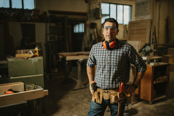 Wall Mural - A mature carpenter standing confidently in his workshop