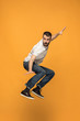 © master1305 - Freedom in moving. handsome young man jumping against orange background