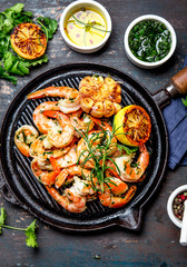 Wall Mural - Grilled shrimps prawns on vintage grill pan, top view. Dark background