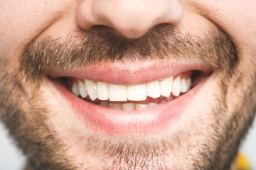 detailed image of young man smiling with perfect white teeth. healthy concept. close-up.