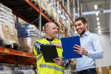 Poster - wholesale, logistic business and people concept - manual worker and businessman with clipboards at warehouse