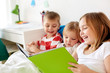 © Syda Productions - childhood, leisure and family concept - little kids reading book in bed at home
