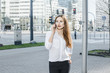 © ibilyk13 - A business woman speaks through the phone. A good girl is sitting on the bench. A young woman in the city center.