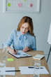 © LIGHTFIELD STUDIOS - portrait of focused businesswoman doing paperwork at workplace in office