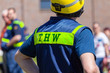 German technical emergency service sign on a vest from a man. THW, Technisches Hilfswerk means technical emergency service.