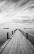 © oatautta - Black and white Landscape of wooden bridge in blue sea on tropical beach .