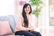 © Africa Studio - Attractive mature woman sitting on sofa at home