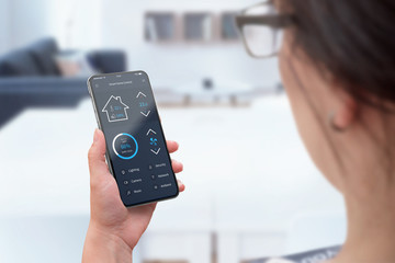 Poster - Woman use moder smart phone with round edges and smart home control app to monitoring temperature, light and security.