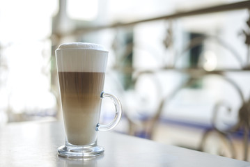 Glass of hot latte on a wooden table