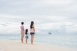 © nareekarn - Happy young family having fun running on beach . Family traveling concept