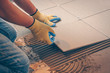 The tile glues the tile to the floor with a glue applied by a notched trowel