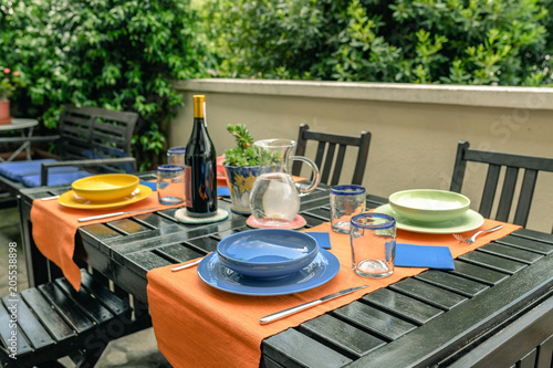 Zdjęcie XXL Zestaw stołowy dla czterech osób. Na gości czekają naczynia, sztućce i napoje. Czekam na przyjaciół na lunch na świeżym powietrzu. Mile widziane chwile dzielenia się z drogimi przyjaciółmi w domu.