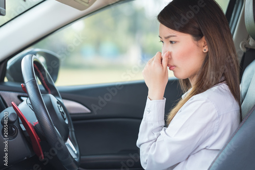 Fotografia, Obraz Young woman holding her nose because of bad smell in car.
