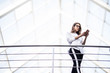 © dianagrytsku - Beautiful young businesswoman using mobile phone in office hall