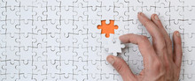 The Texture Of A White Jigsaw Puzzle In The Assembled State With One Missing Element That The Male Hand Puts In