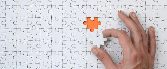 the texture of a white jigsaw puzzle in the assembled state with one missing element that the male h