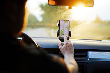 Wall Mural - driver uses navigation on his mobile phone in the car