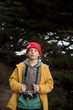 © Cavan Images - Boy with camera standing against trees in forest
