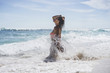 © Cavan Images - Side view of woman standing in sea on shore during summer