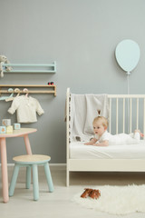 Wall Mural - Adorable baby in the white outfit in the nursery