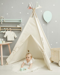 

Adorable baby girl laying on the floor in her nursery under the tent