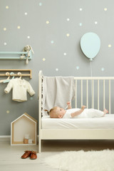 Wall Mural - Adorable baby in the white outfit in the nursery