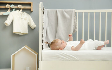 Wall Mural - Adorable baby in the white outfit in the nursery