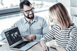 © Viacheslav Yakobchuk - New program. Bespectacled pleasant friendly man sitting opposite his colleague smiling and demonstrating program.