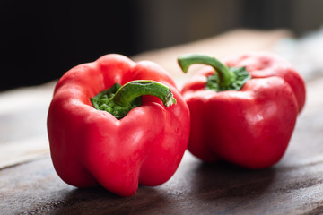 Red bell peppers or sweet peppers on wooden background