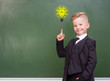 © Ermolaev Alexandr - boy stands near empty chalkboard and showing finger up. Idea concept