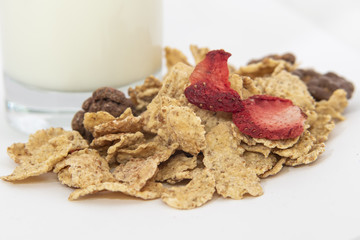 Cereal flakes with strawberry and milk on white background