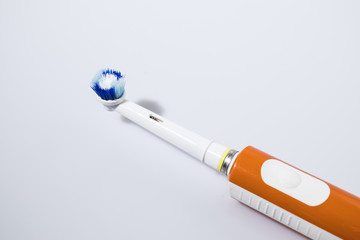 Orange electric toothbrush isolated in a white background