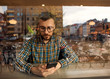 © Rock and Wasp - fashion guy with glasses and checkered shirt sitting in a cafe working in the phone