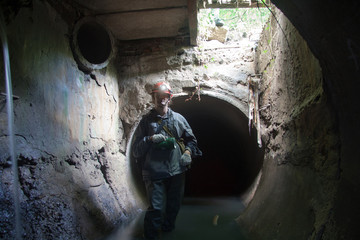 Wall Mural - Sewer worker in underground flooded sewage collector