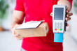 © Elnur - Parcel delivery being paid with pos and credit card