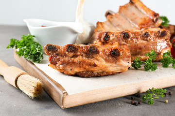 Sticker - Wooden board with delicious grilled ribs on table